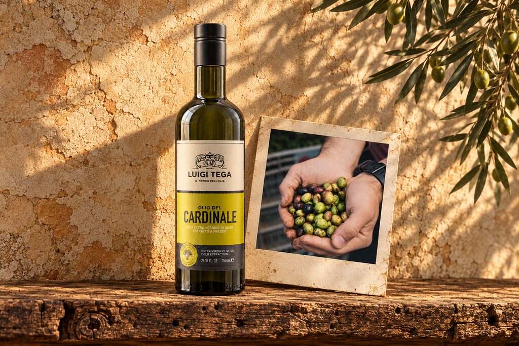 Olio del Cardinale on a rustic wooden shelf beside a photograph of freshly harvested olives
